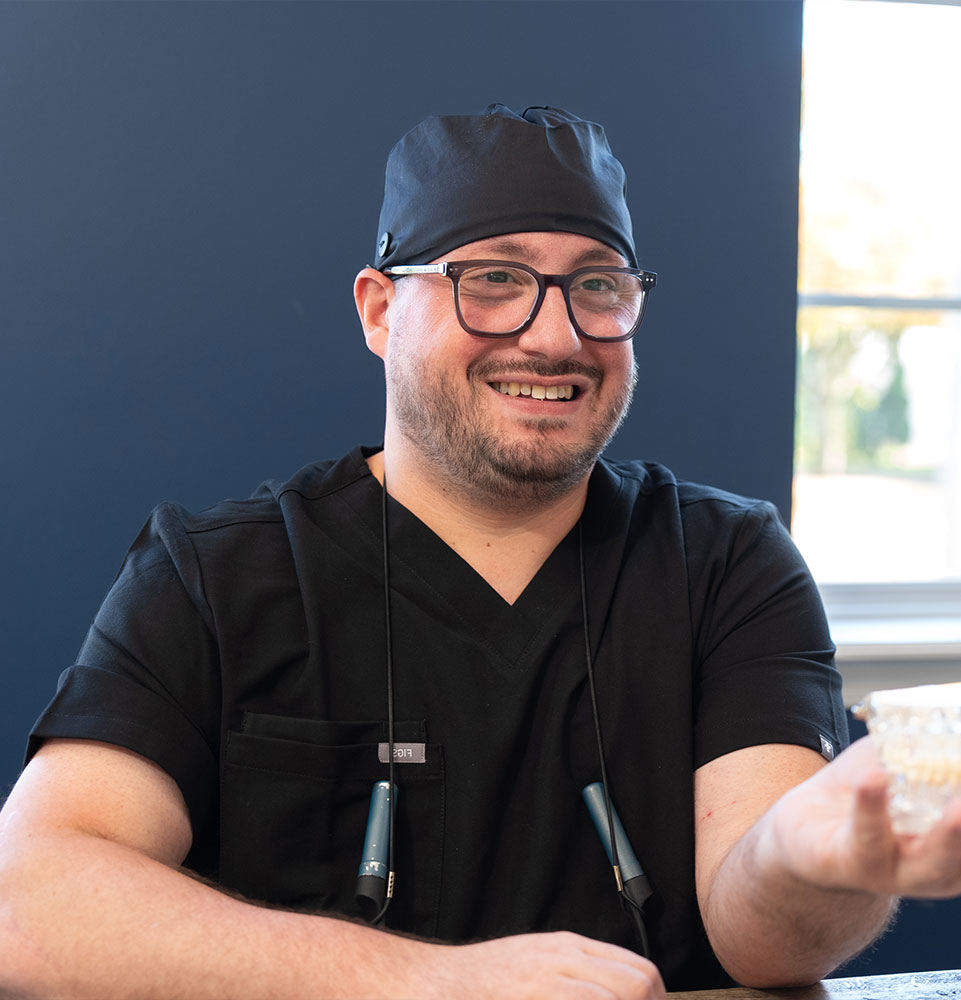 doctor showing patient a dental implant model during their consultation