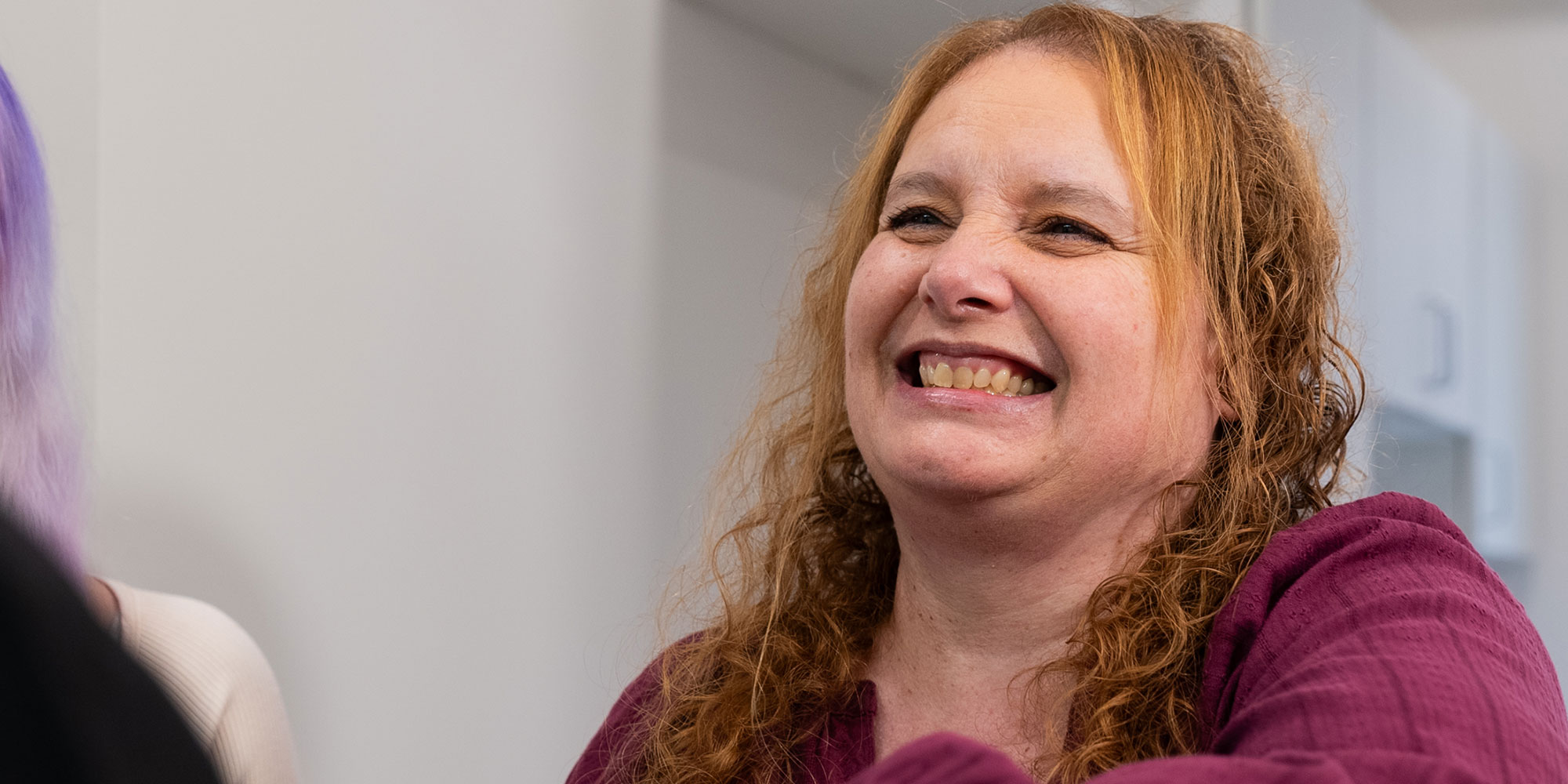 patient smiling brightly while being greeted by dental staff member