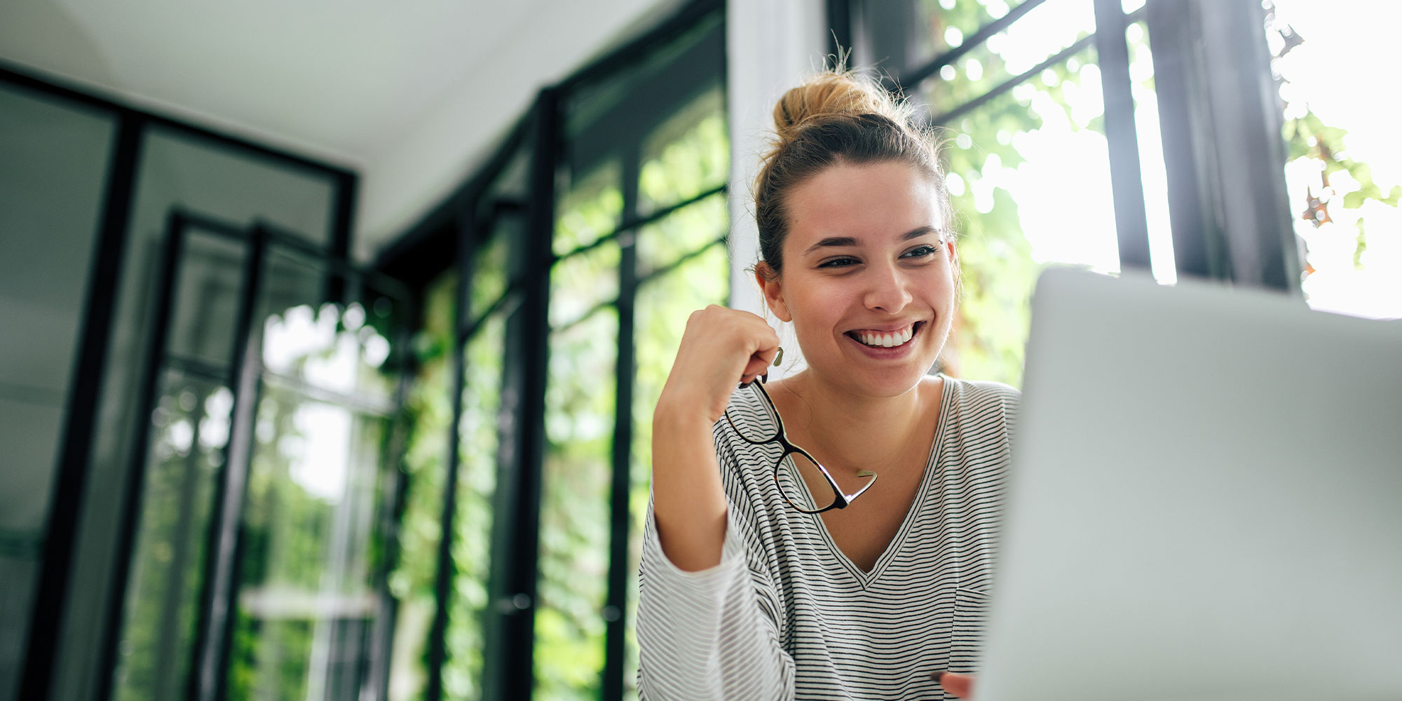 person smiling brightly while on their laptop