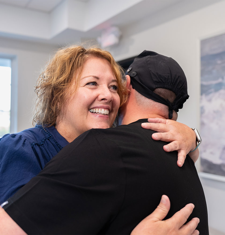 patient hugging doctor after patient's dental treatment